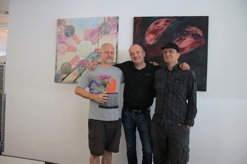 „Kunst in der Kantine“ kommt an. In der Mitte Küchenchef Nik Mroch mit den beiden Künstlern Oliver Carlos Tüchsen (links) und Martin Holzschuh.