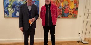 Galerist Peter Femfert (li.) zusammen mit dem Künstler Klaus Zylla vor dem Gemälde „Die Ratlosen“ Foto: Edda Rössler
